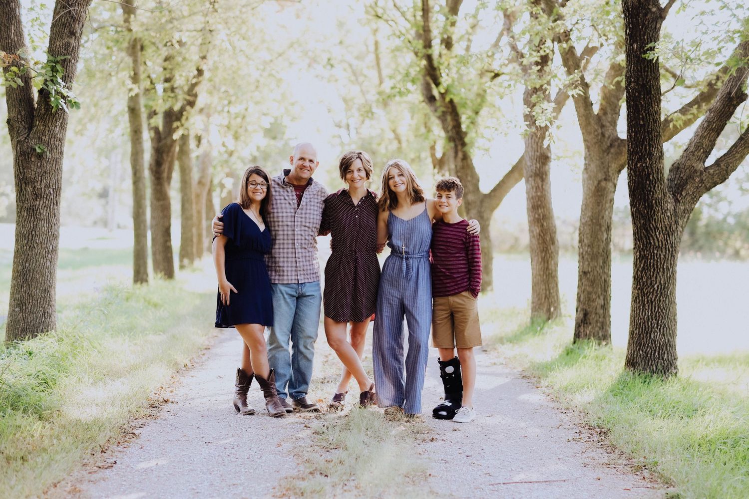 Group walking together on tree-lined path in natural setting.