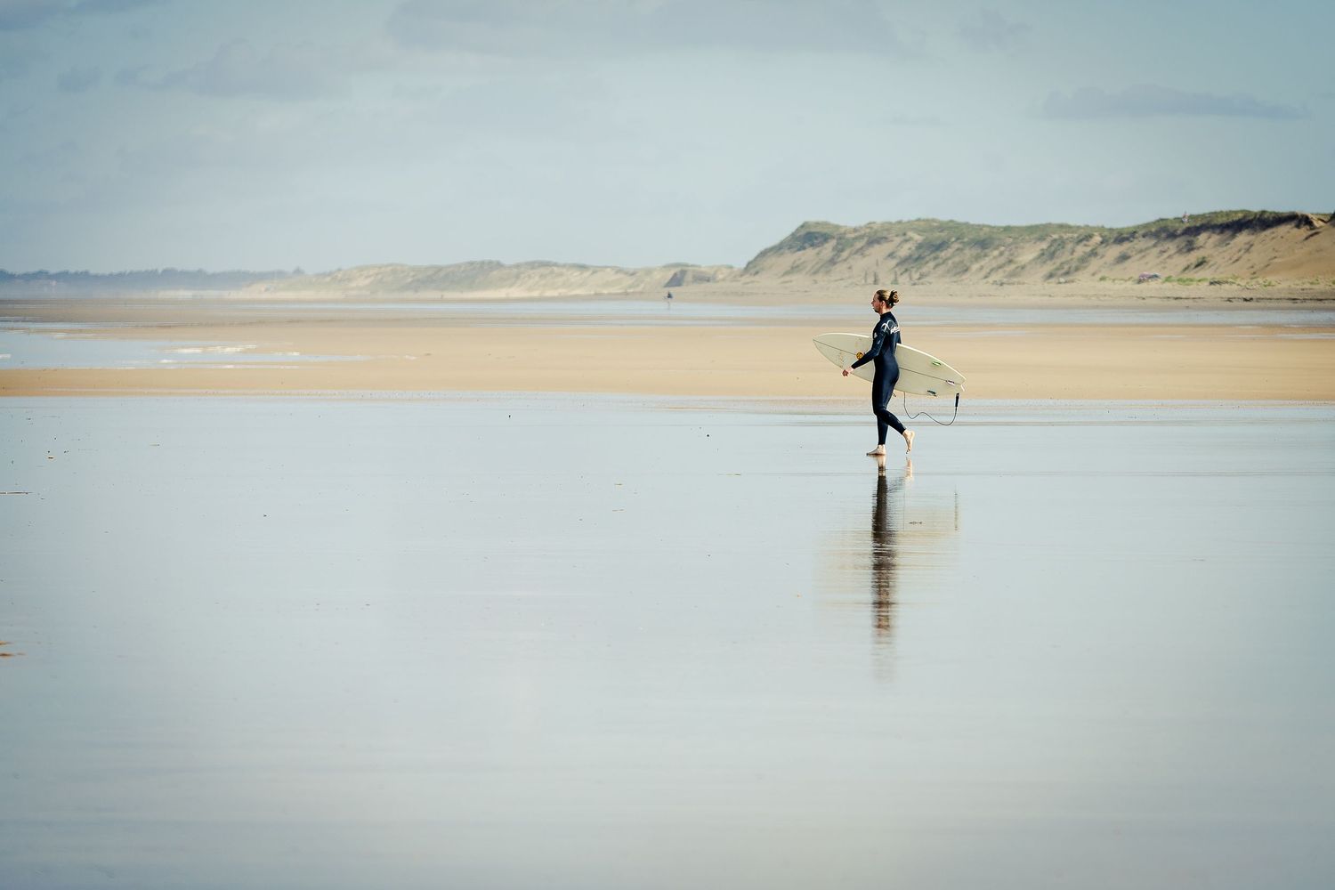 Surfer walking on the beach with his board