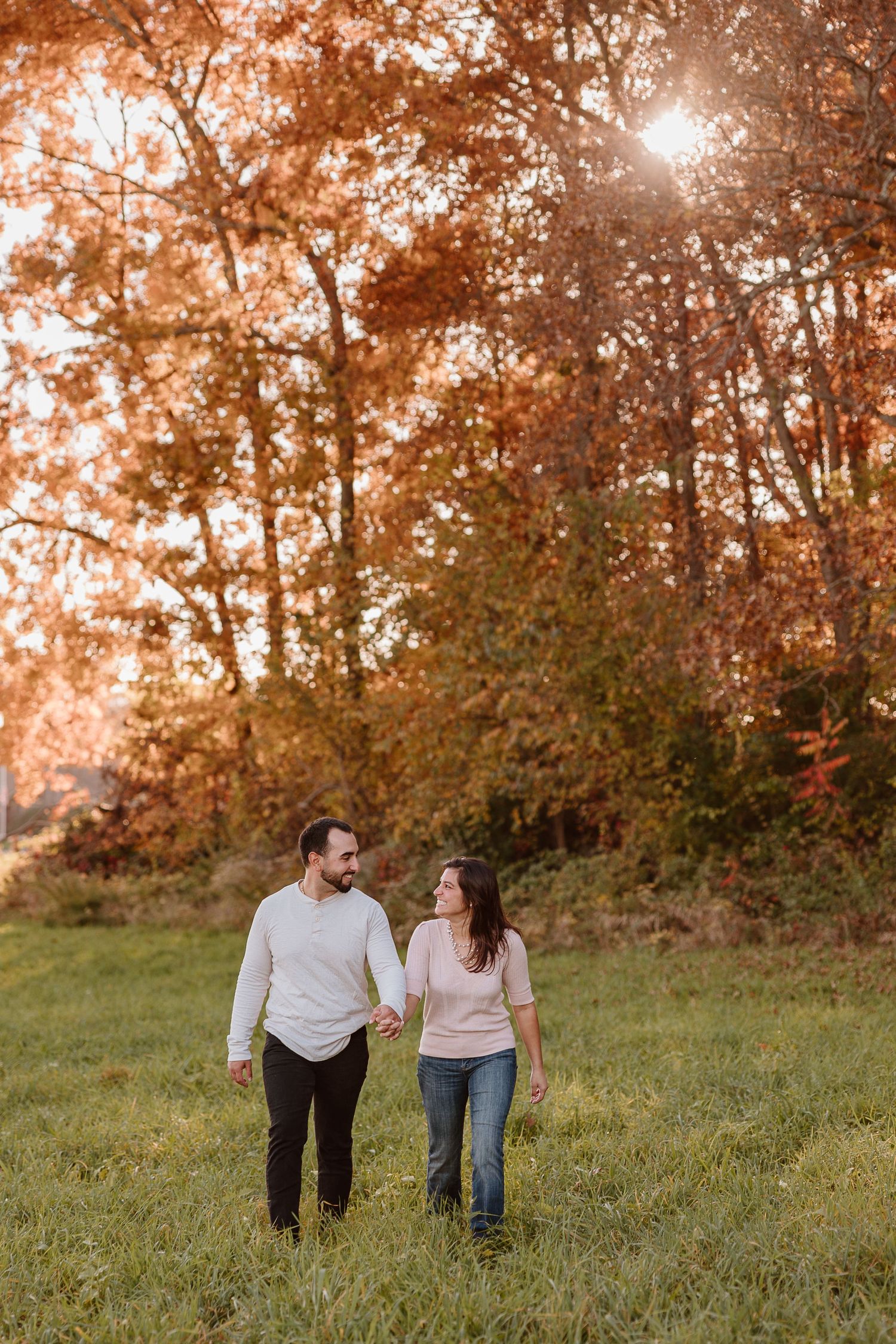 couple looking at each other walking towards new england engagement photographer