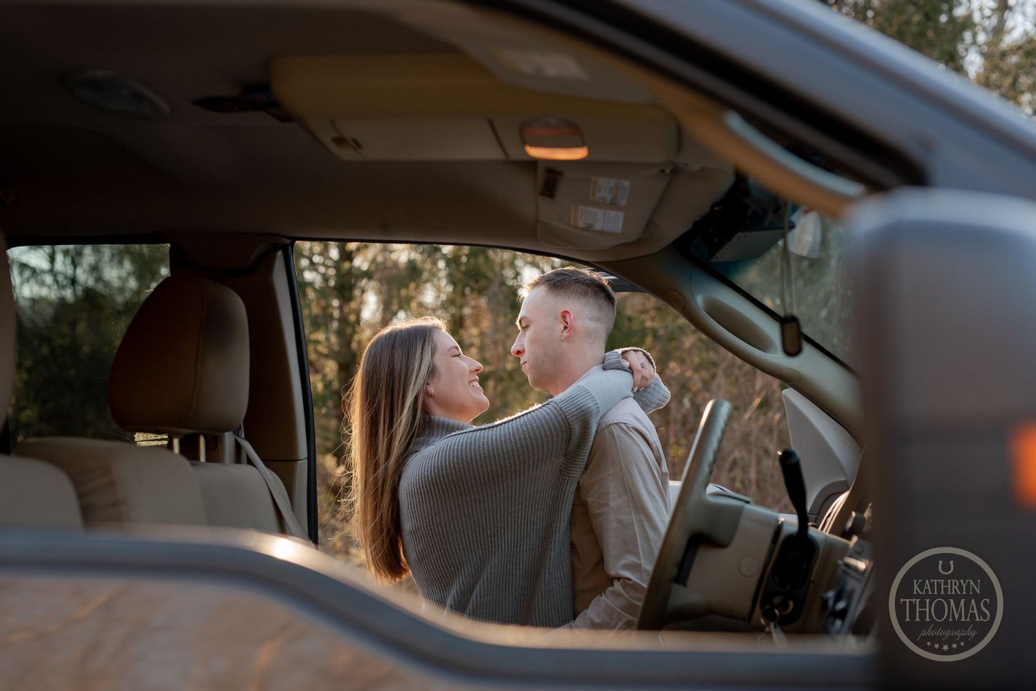 Intimate moment captured through car window of couple in front seat.