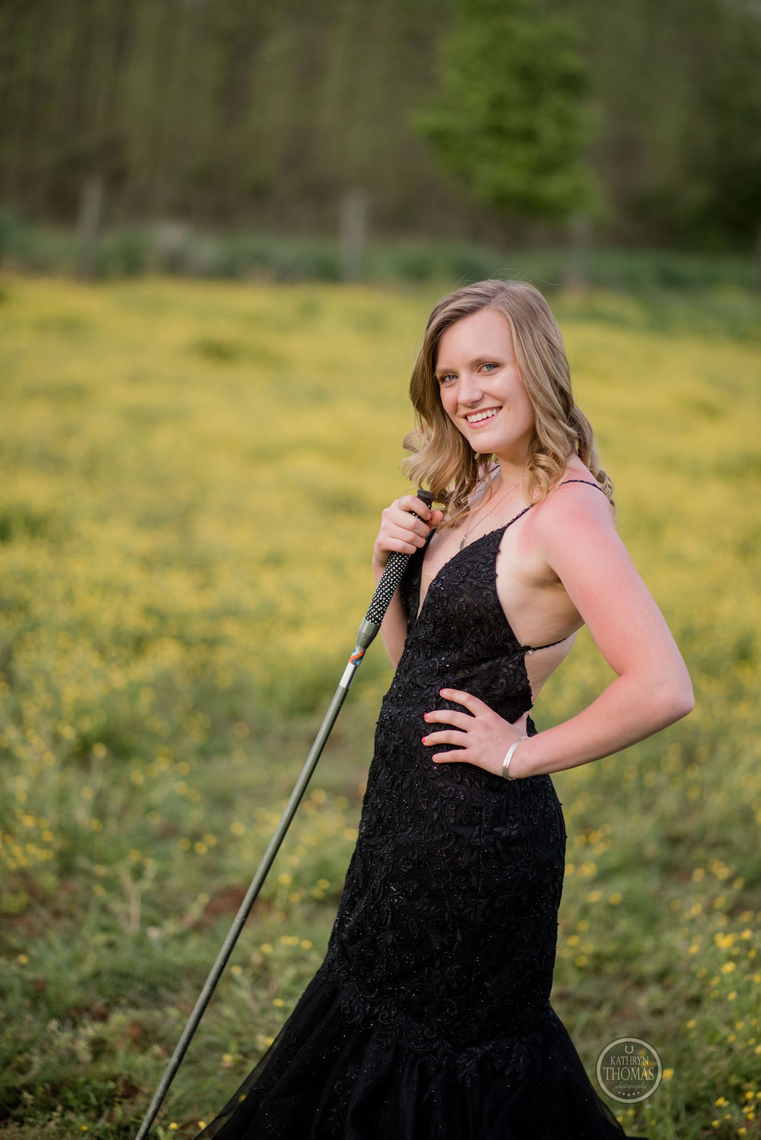 A formal portrait in a black evening gown against a background of spring wildflowers.