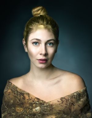 Elegant creative portrait featuring sparkly gold off-shoulder dress and styled blonde hair.