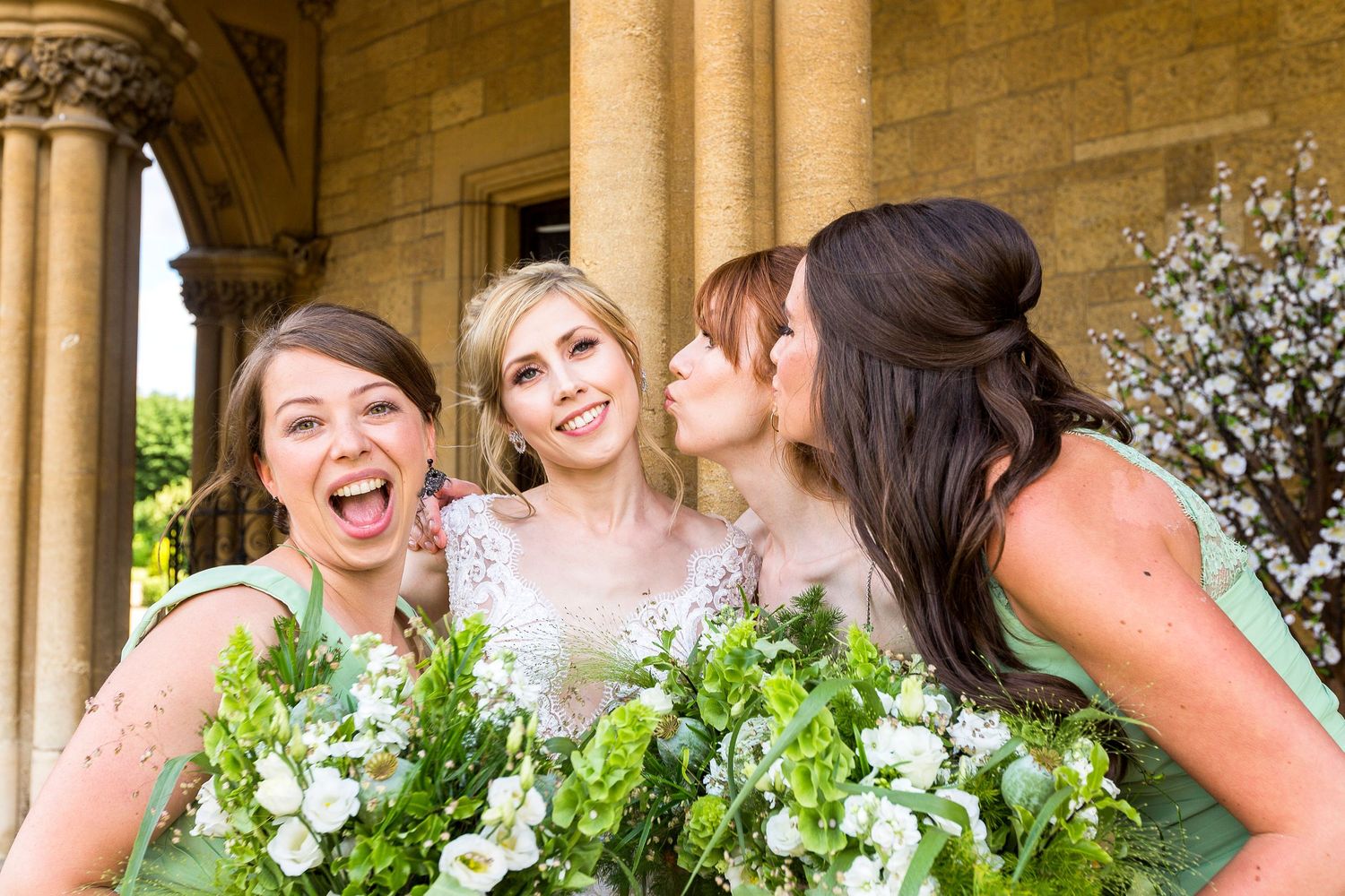 three bridesmaids close to bride blowing kisses all laughing