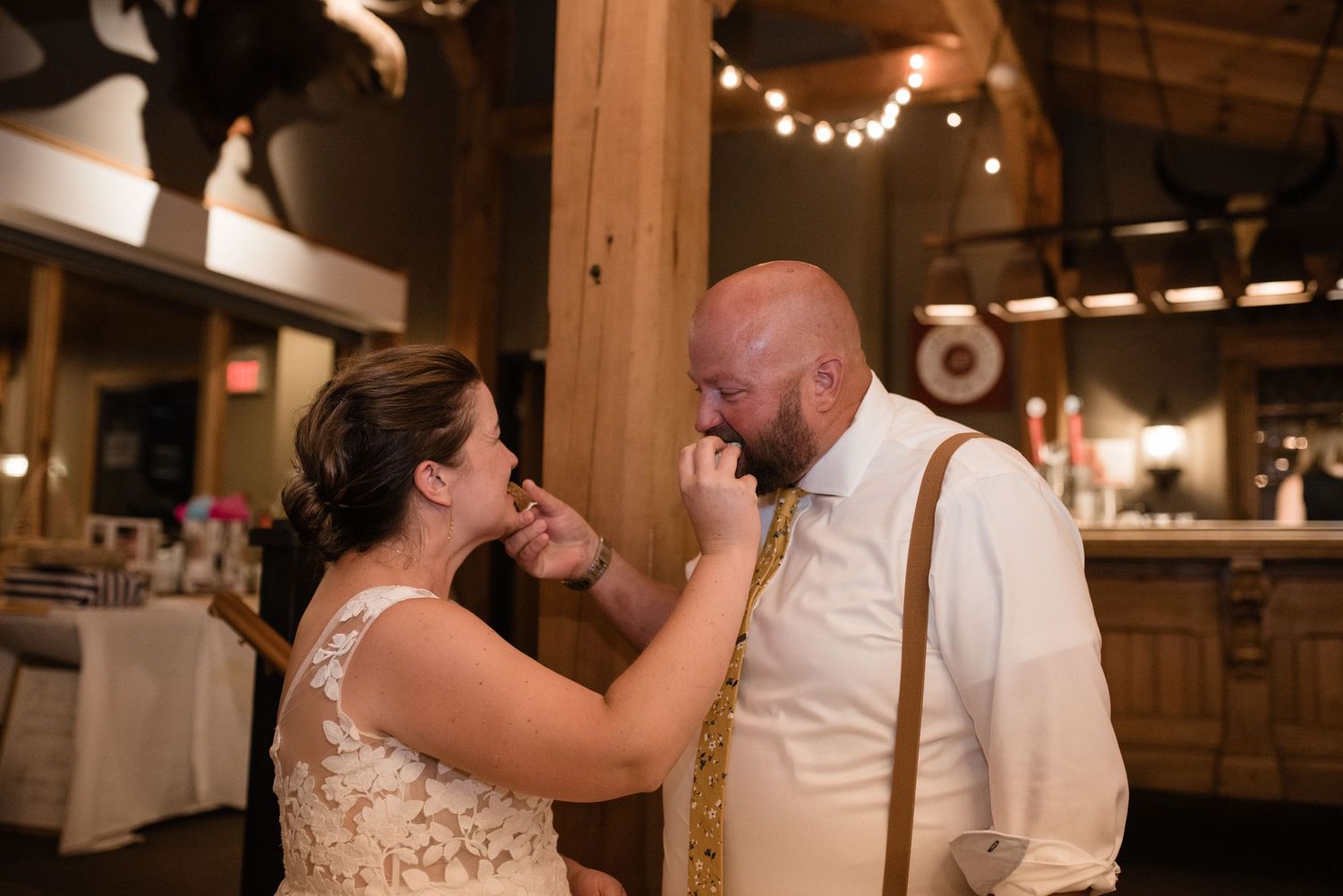 Intimate moment shared between newlyweds during their reception in a rustic wooden venue.