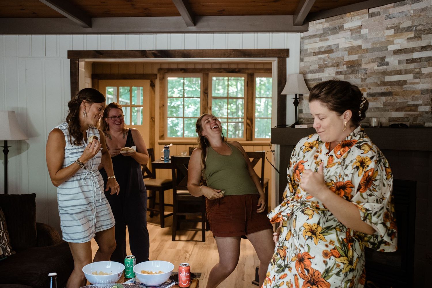 Friends enjoying snacks and conversation in a rustic room with exposed brick walls.
