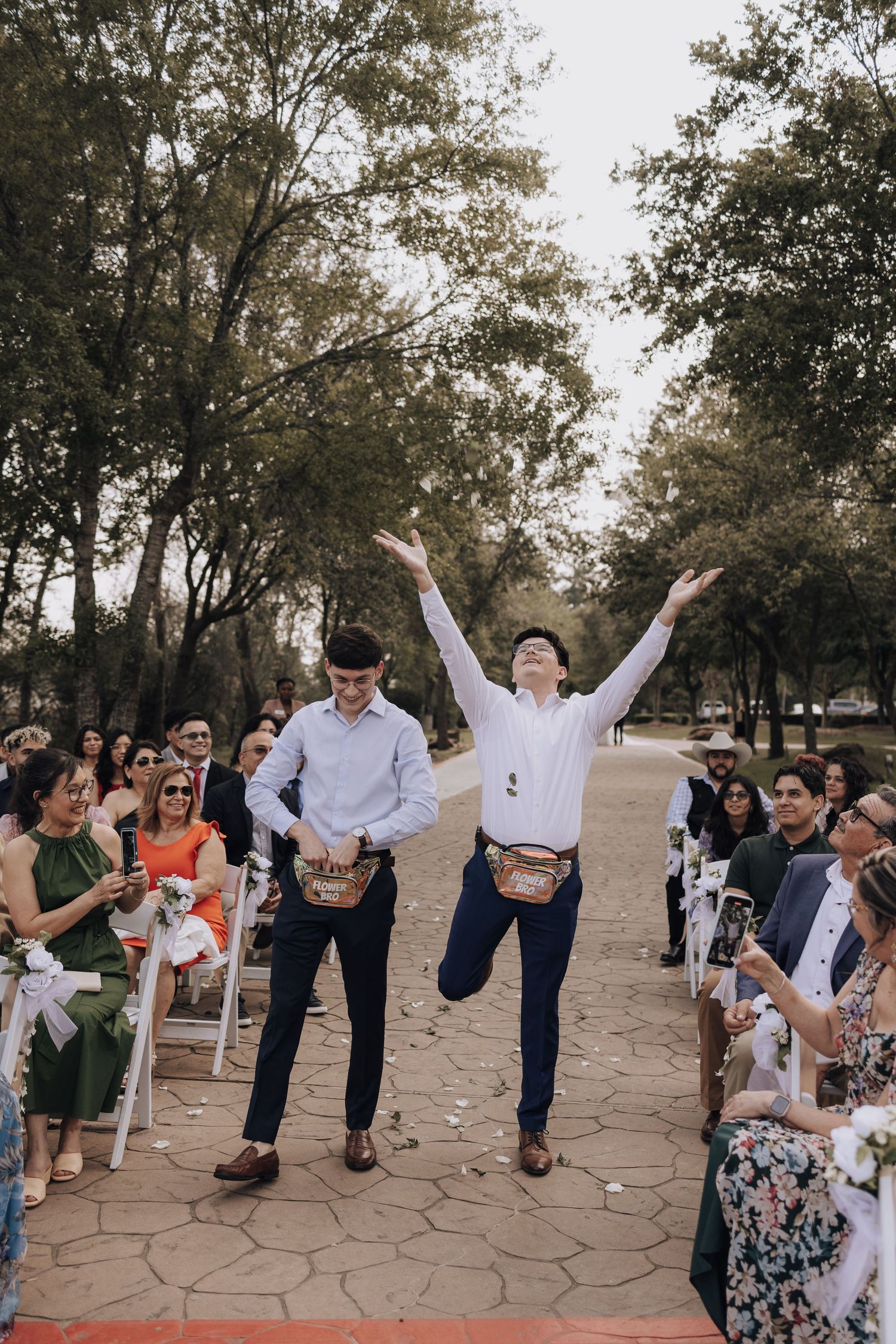 Celebratory dance performance during outdoor wedding ceremony with seated guests watching.
