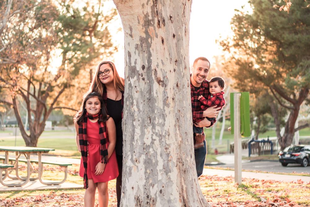 Outdoor Family Photography in a park in Fresno, California Photoshoot Hiding behind Tree