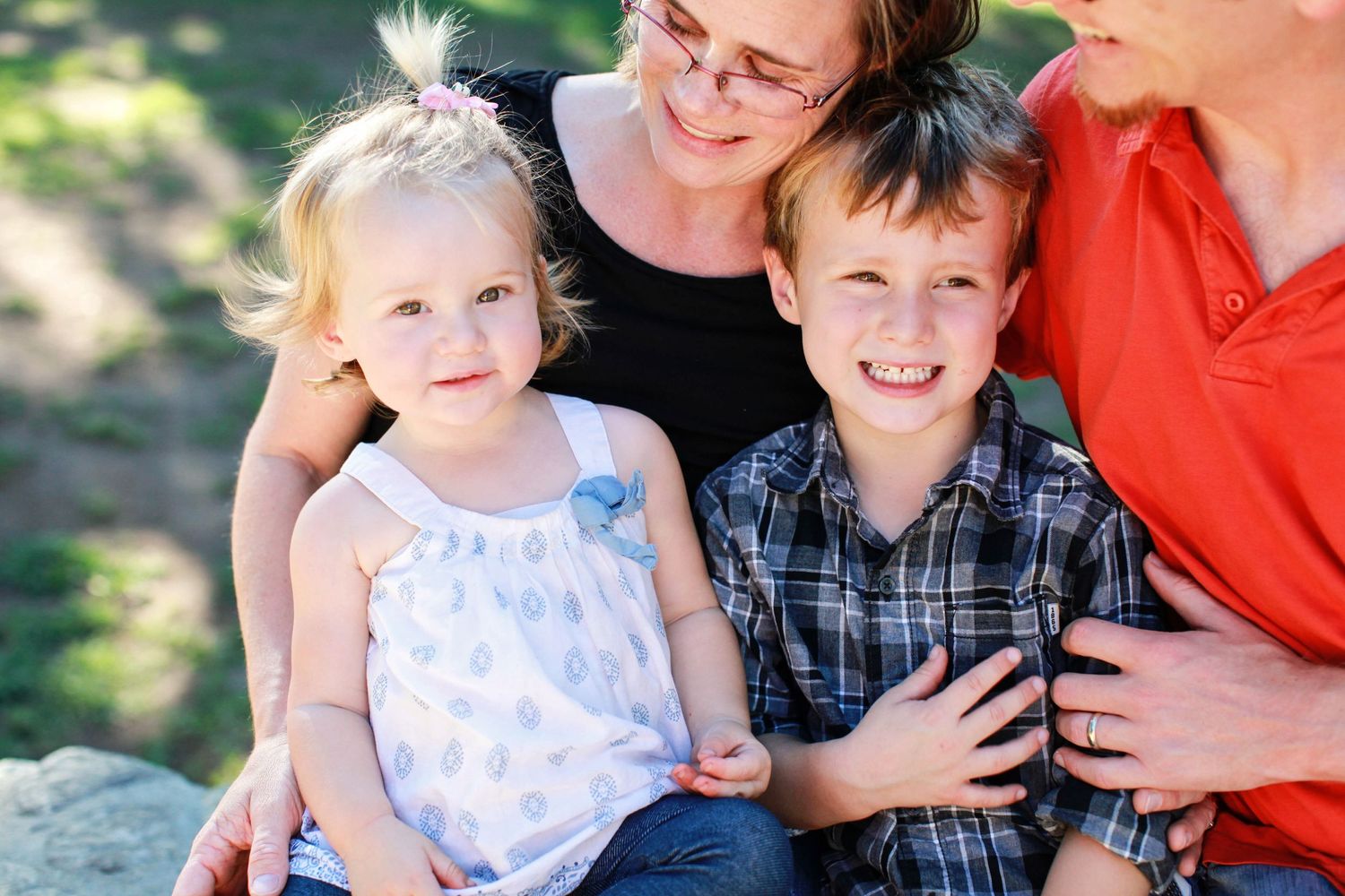 Family portrait on a sunny day with children in casual attire.