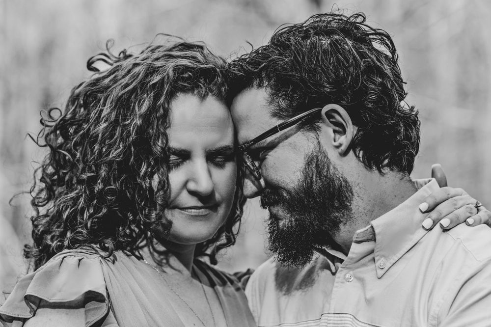 An intimate black and white portrait of a couple sharing a tender moment.