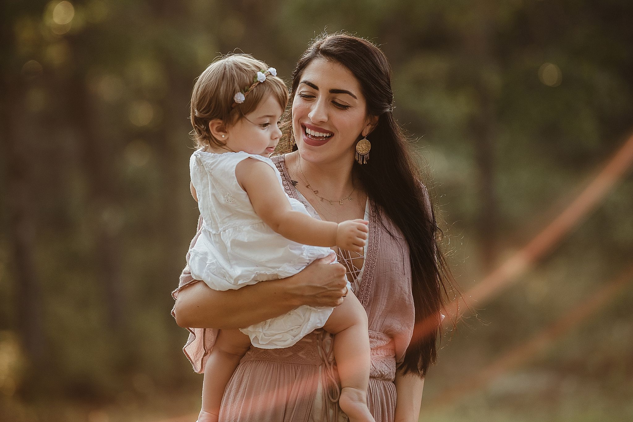 A joyful outdoor portrait in golden light showing tender family affection.