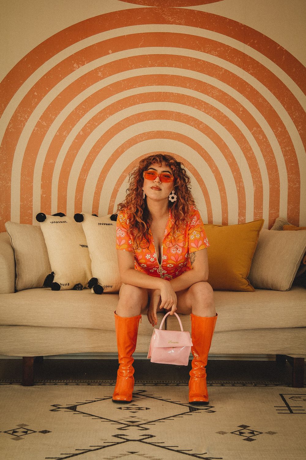 Fashion photo with orange retro vibes featuring boots and circular wall design.