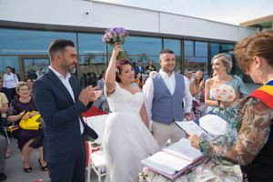 Wedding party gathers outside modern venue for ceremony photos.
