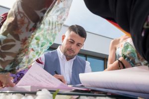 Close-up view of wedding document signing with floral bouquet on table.
