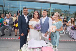 Wedding guests watching ceremony outside contemporary glass building.