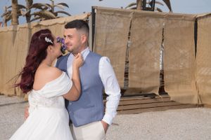 A romantic moment captured against rustic wooden walls and desert landscaping.