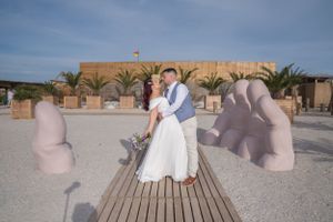Wooden boardwalk with decorative elements and seating areas along a beachfront.