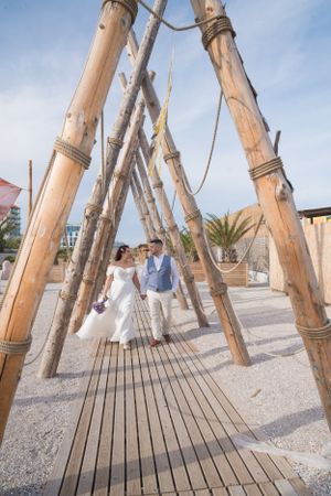 Artistic arrangement of bamboo poles creates geometric patterns against a blue sky.