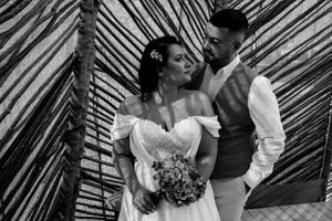 Intimate black and white wedding portraits against bamboo wall backdrop.