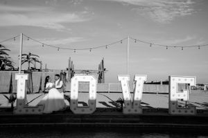Black and white panoramic view of an outdoor wedding venue with desert landscaping and string lights.