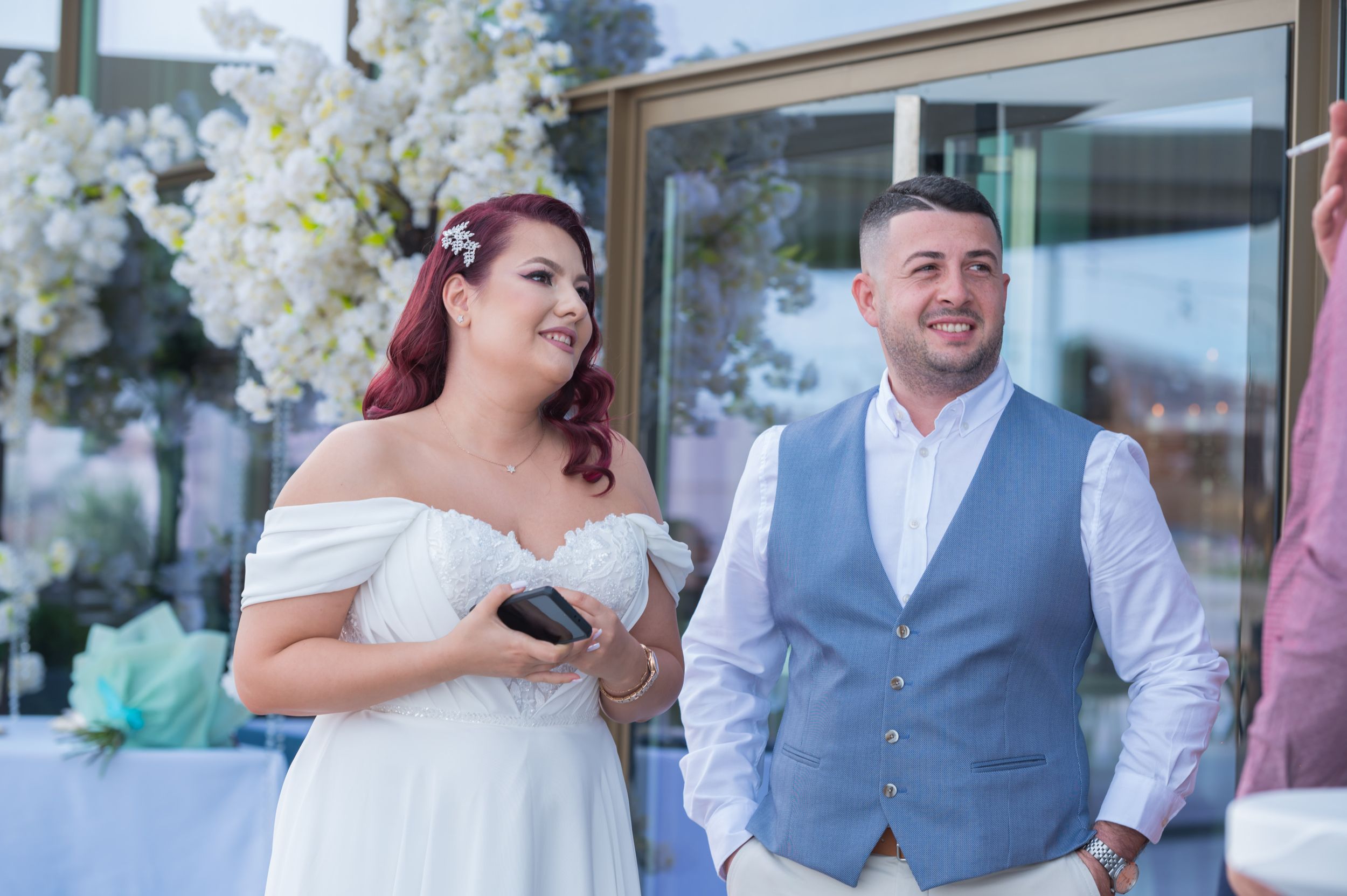 Wedding celebration at a venue decorated with white floral arrangements and elegant decor.