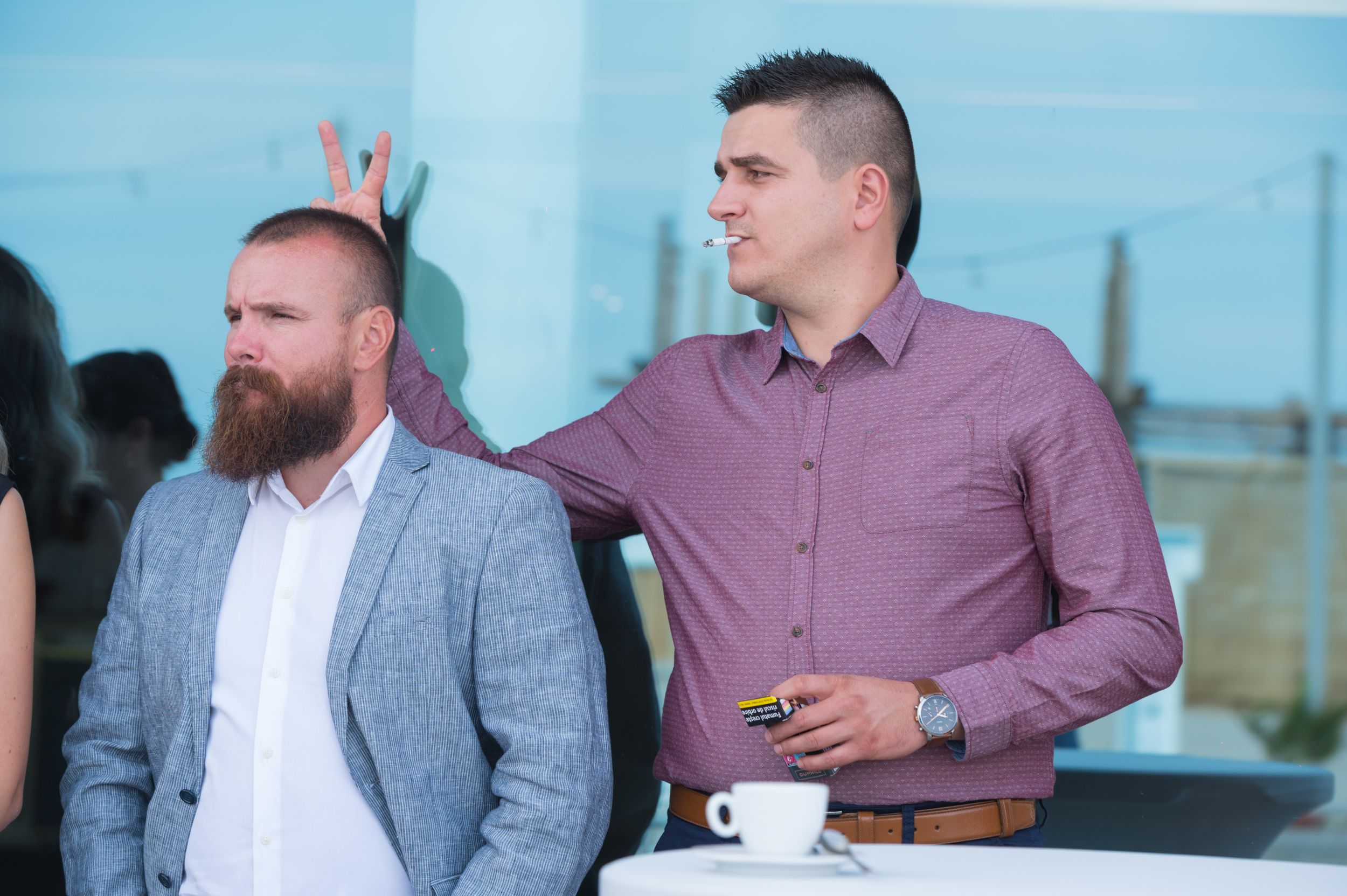 Groomsmen in casual attire sharing conversation during wedding celebrations.