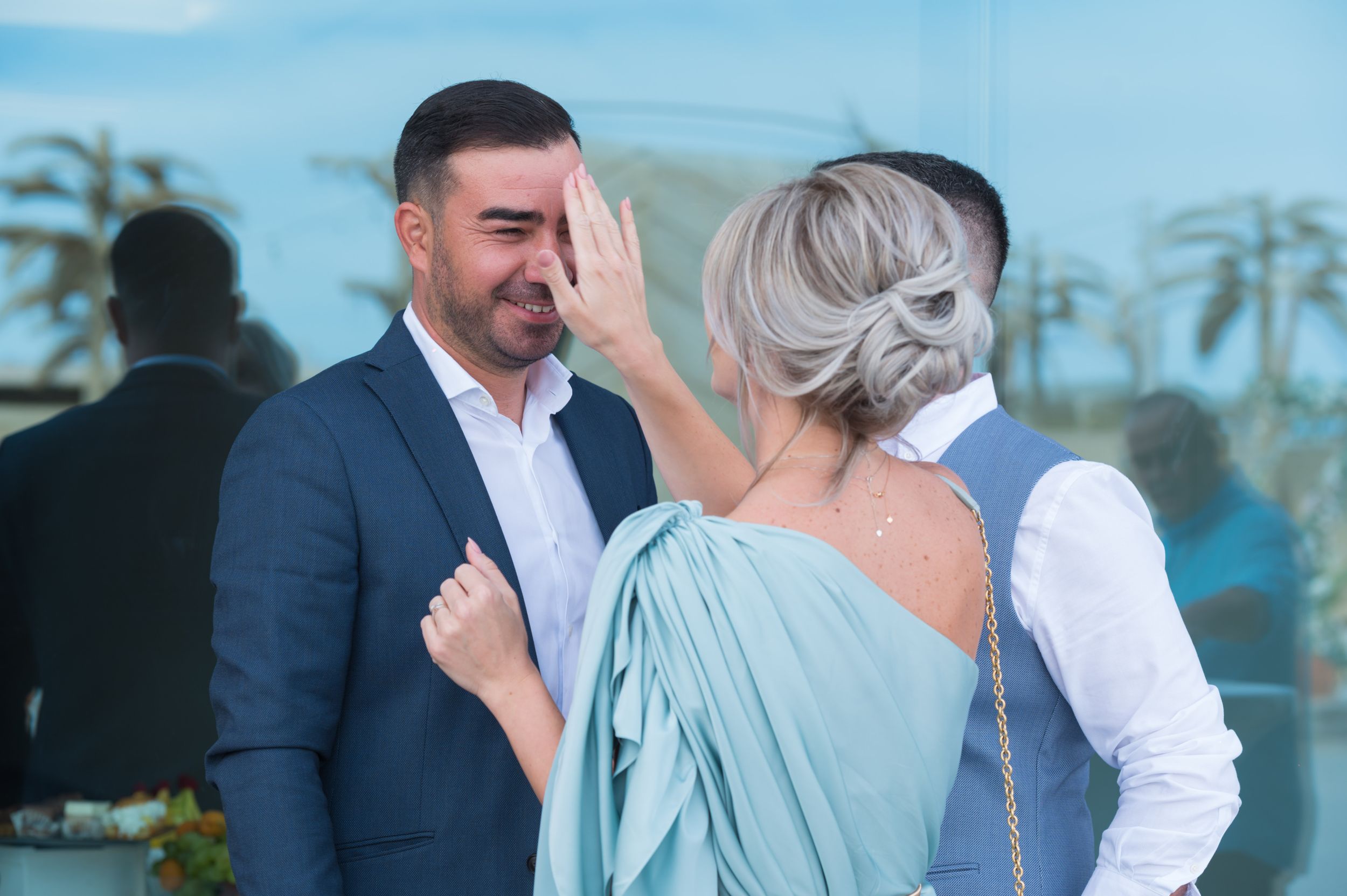 Wedding party members in formal attire socializing at an outdoor venue.