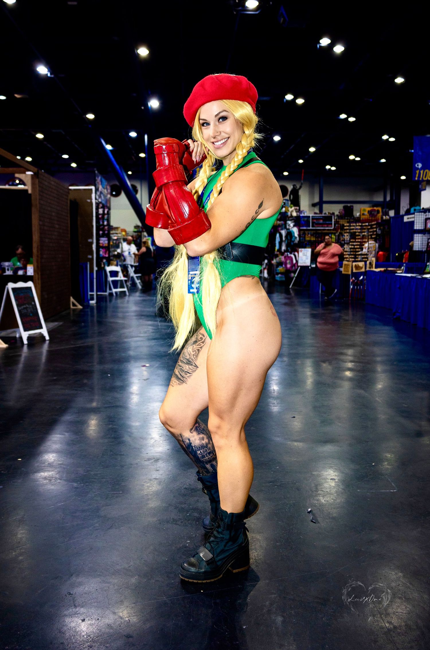 Street Fighter Cammy cosplay in classic green leotard outfit at gaming convention.