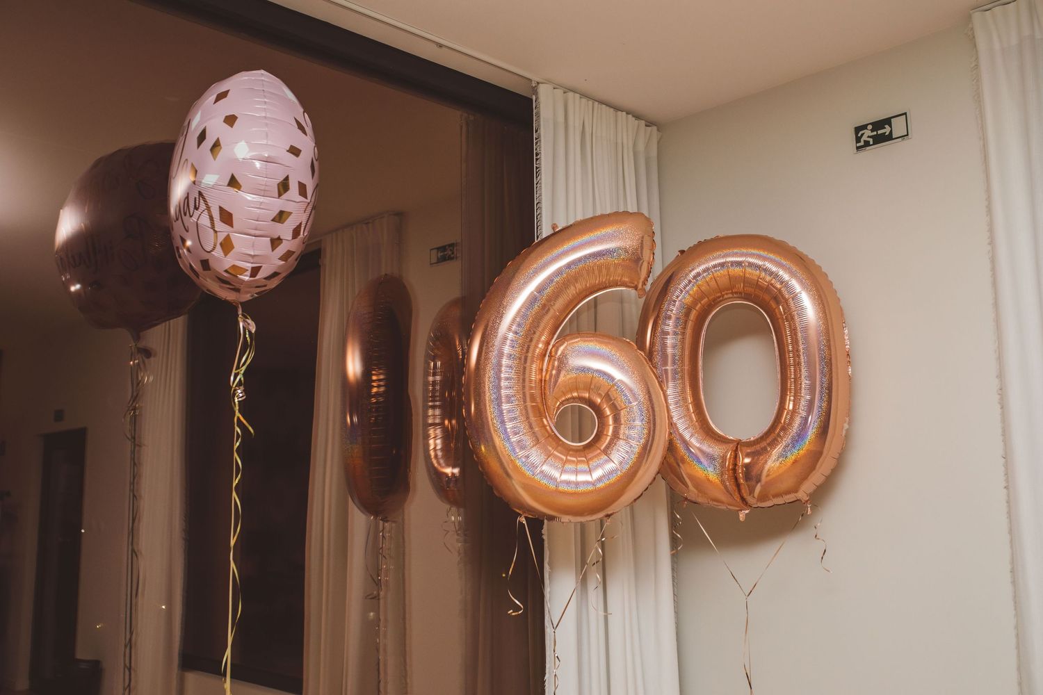 Rose gold number balloons spelling out 60 decorate an indoor celebration space.