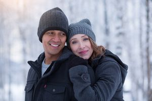 Happy group poses together in winter attire with snow-covered trees in background.