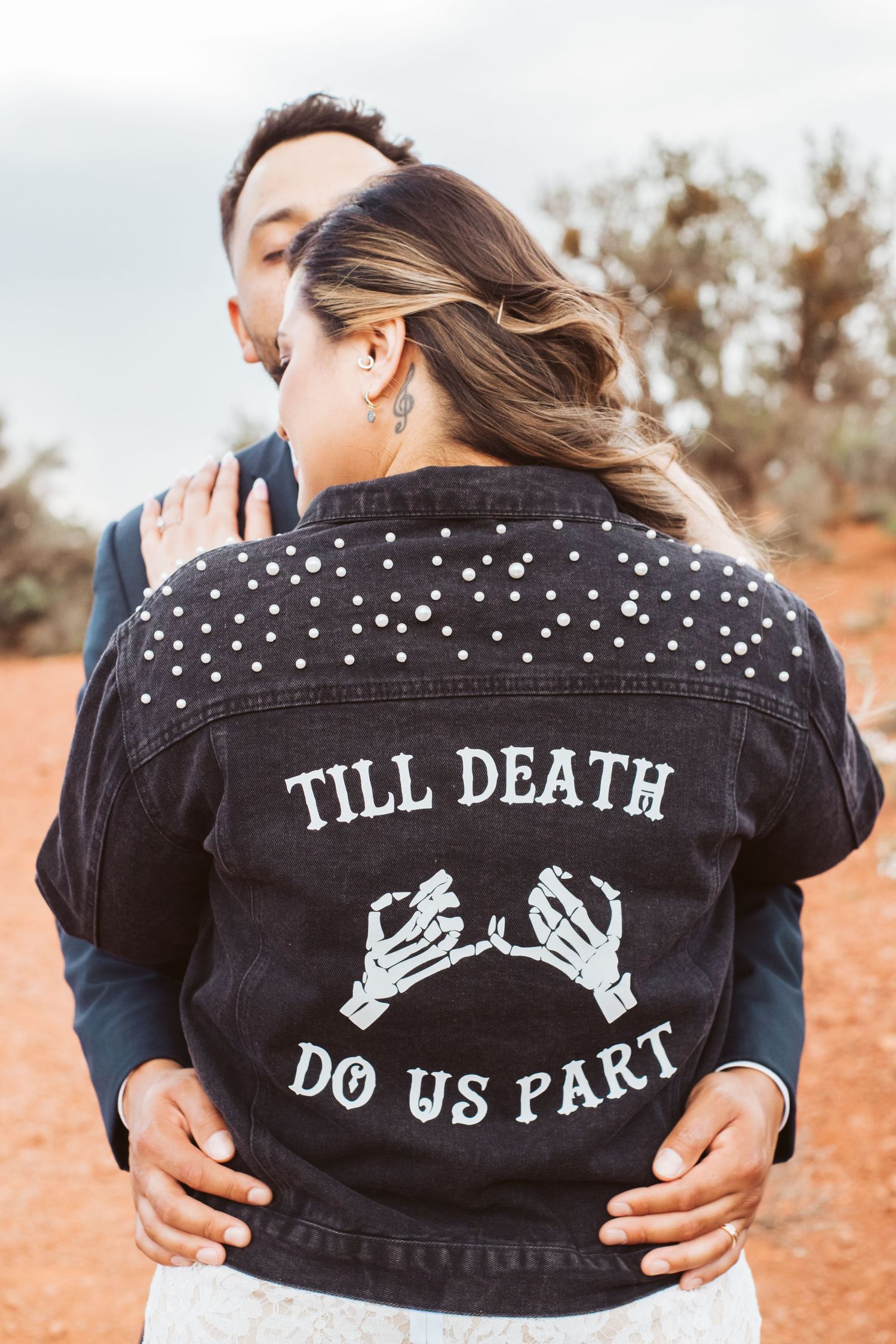 Custom denim jacket with 'Till Death Do Us Part' skeleton design worn by bride.