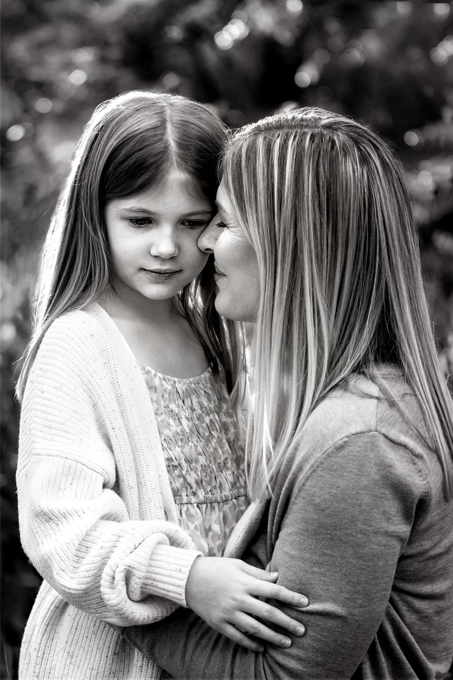 black and white portrait of mom nuzzling the cheek of her seven year old daughter
