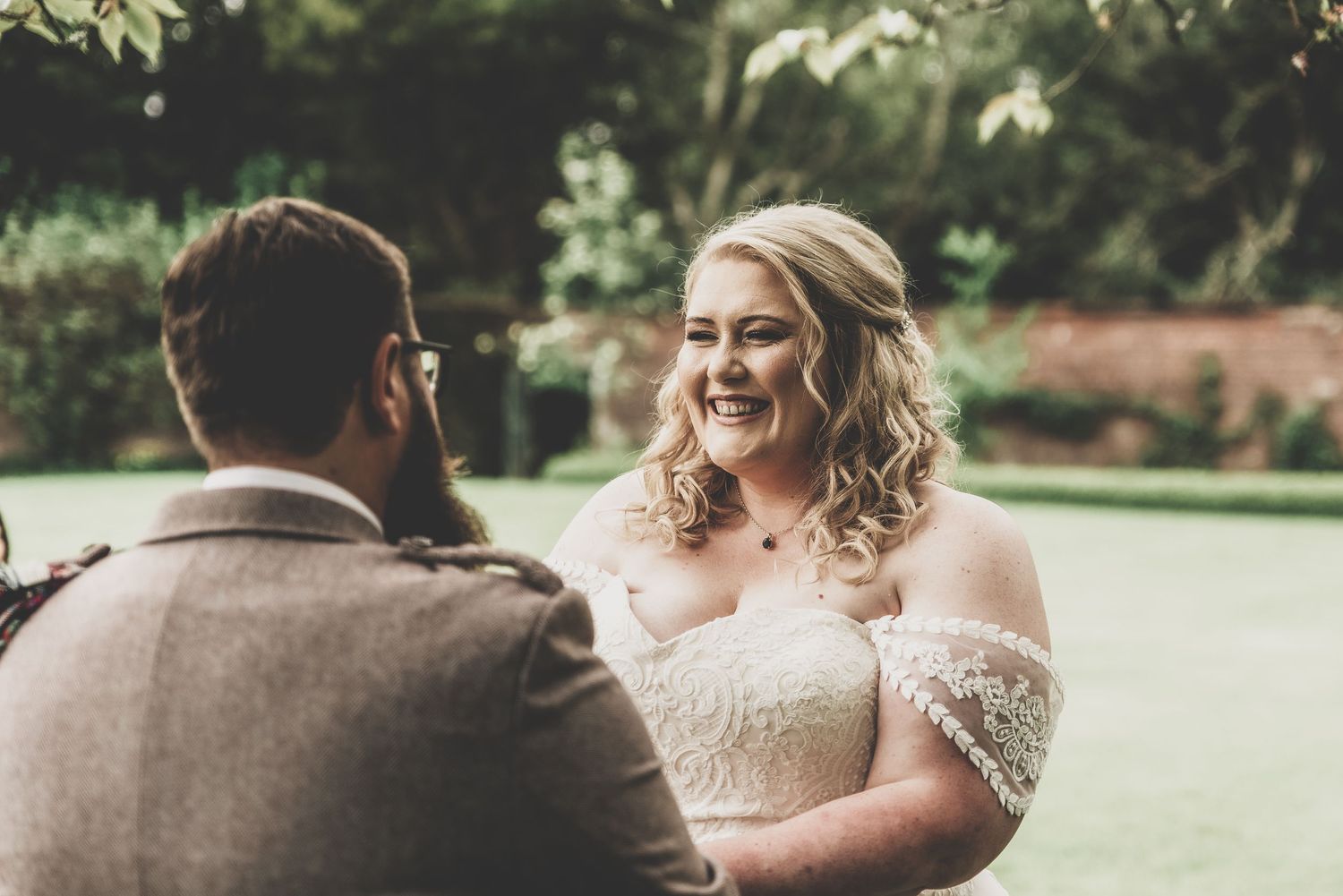 A candid wedding moment showing joyful interaction between a couple outdoors.