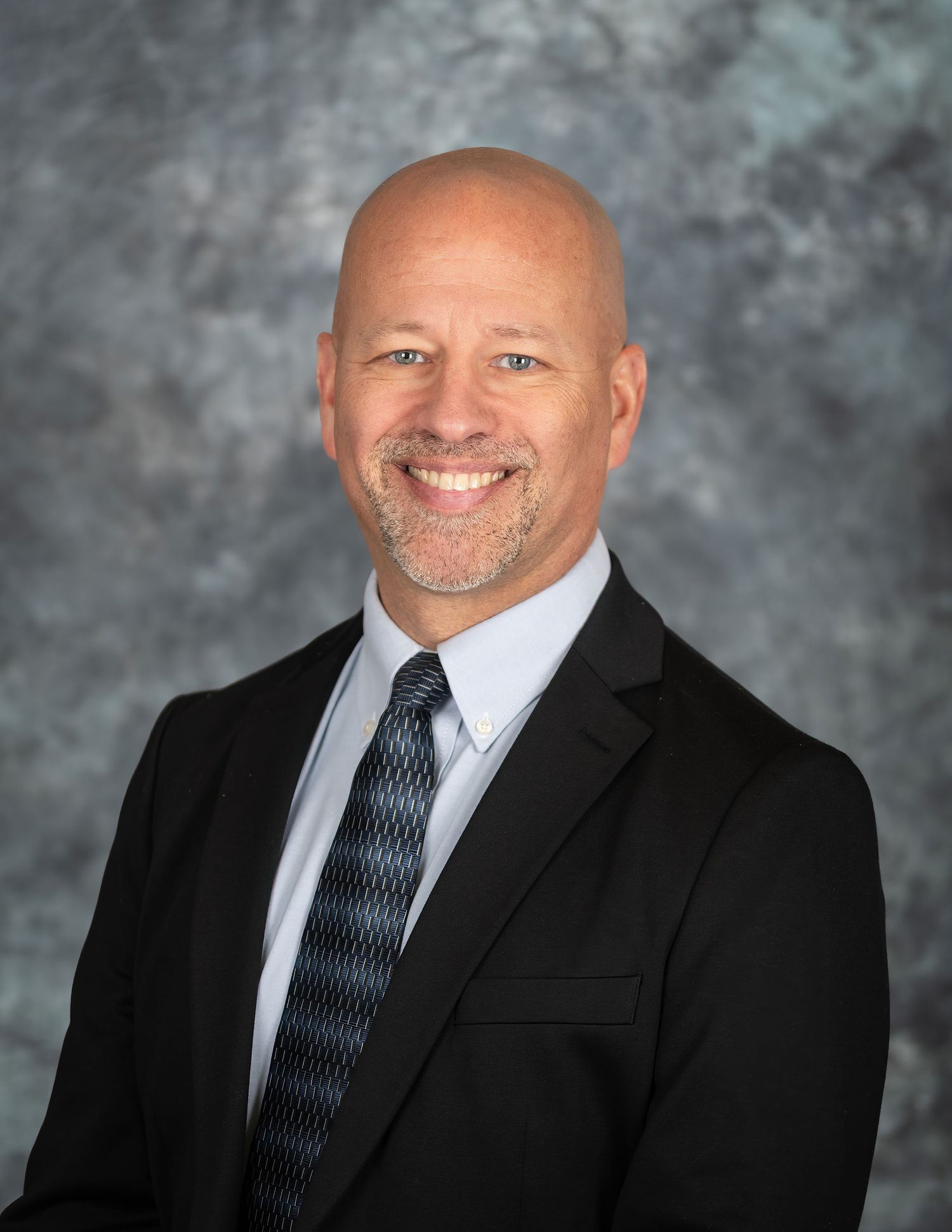 Professional headshot series showing different angles in business attire against gray backdrop.