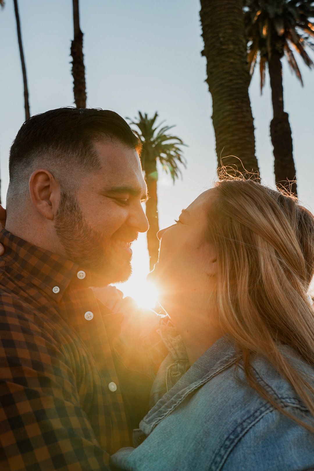 Romantic sunset silhouette with palm trees creating a dreamy backlit scene.
