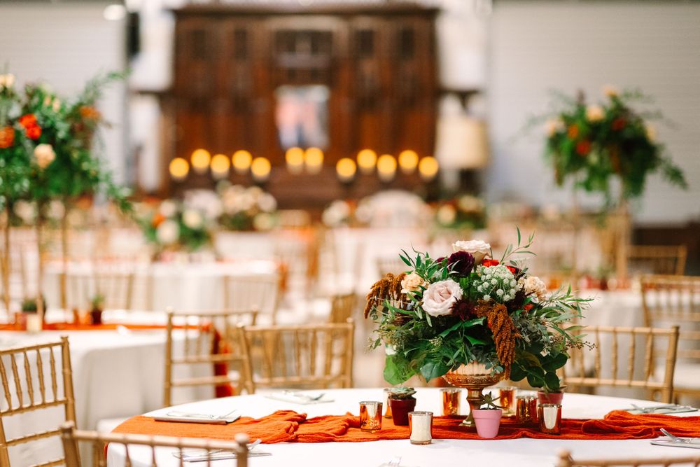 Elegant wedding reception setup with floral centerpieces and gold chiavari chairs.