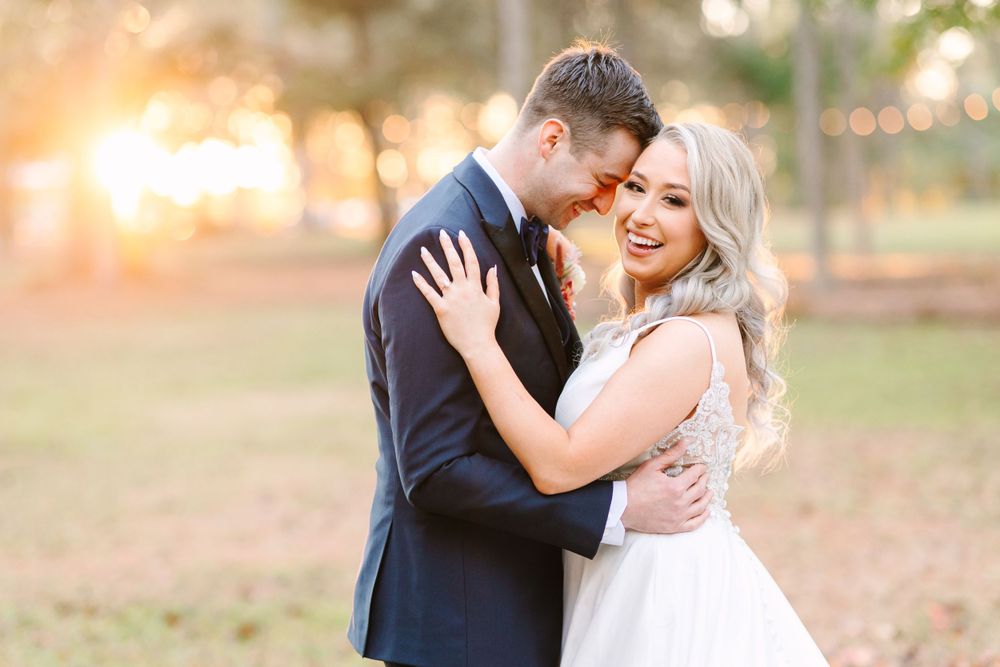 Joyful wedding couple embraces during golden hour sunset portrait session.