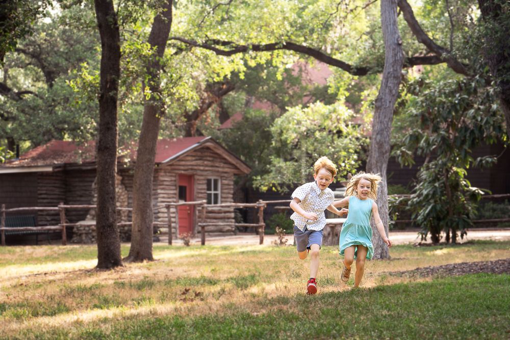 Landa Gardens at Landa Library boy and girl siblings running across the grounds