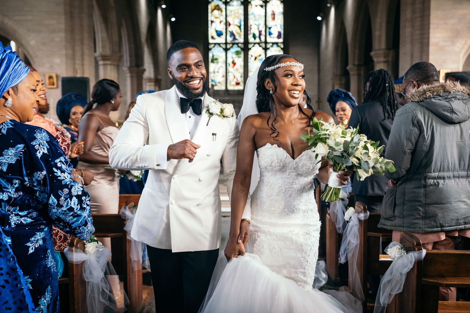 Joyful wedding ceremony exit in church with guests celebrating.