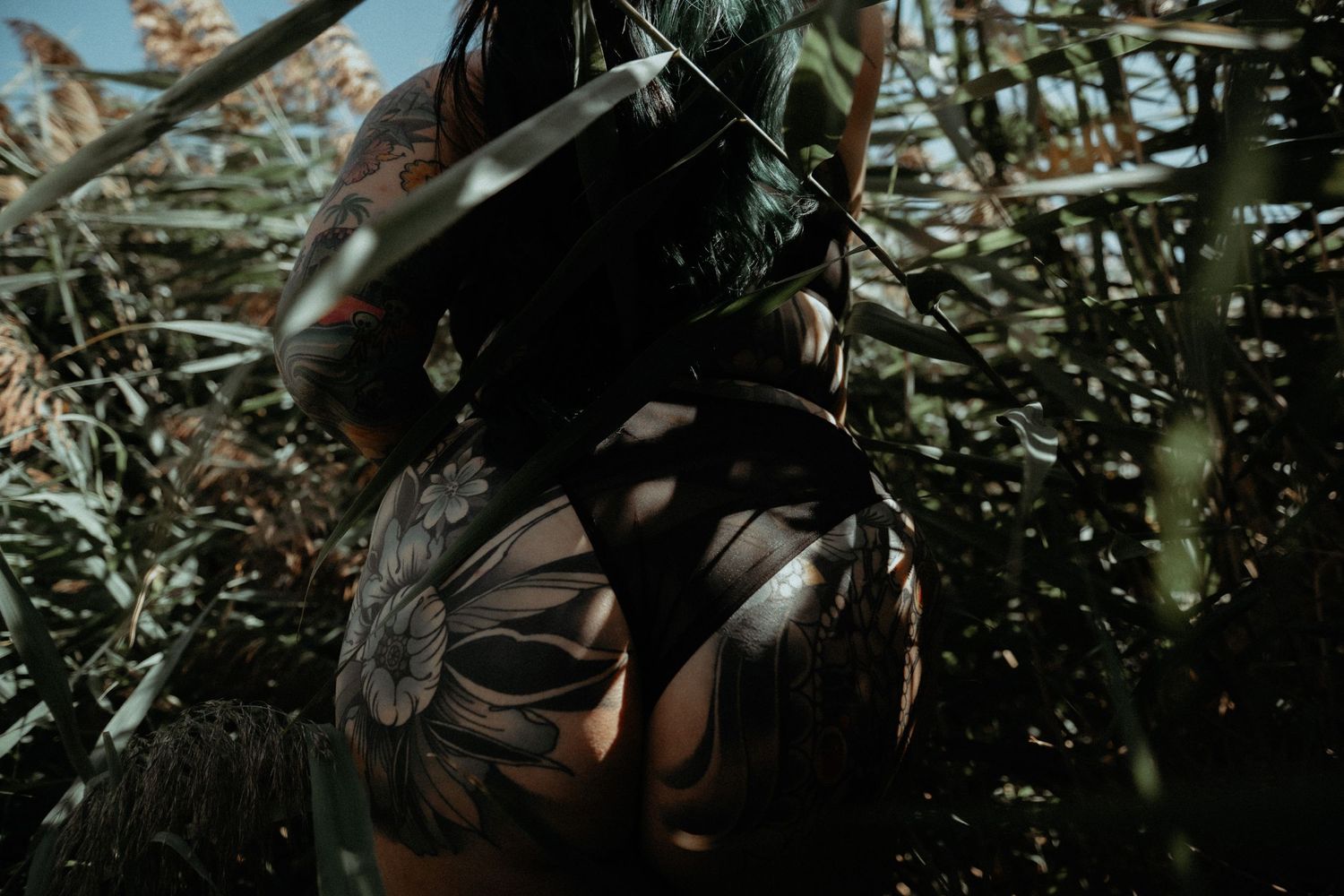 Outdoor boudoir portrait of woman embracing natural light and scenery