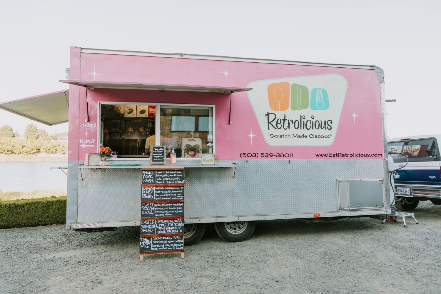 Pink food truck with menu sitting out front