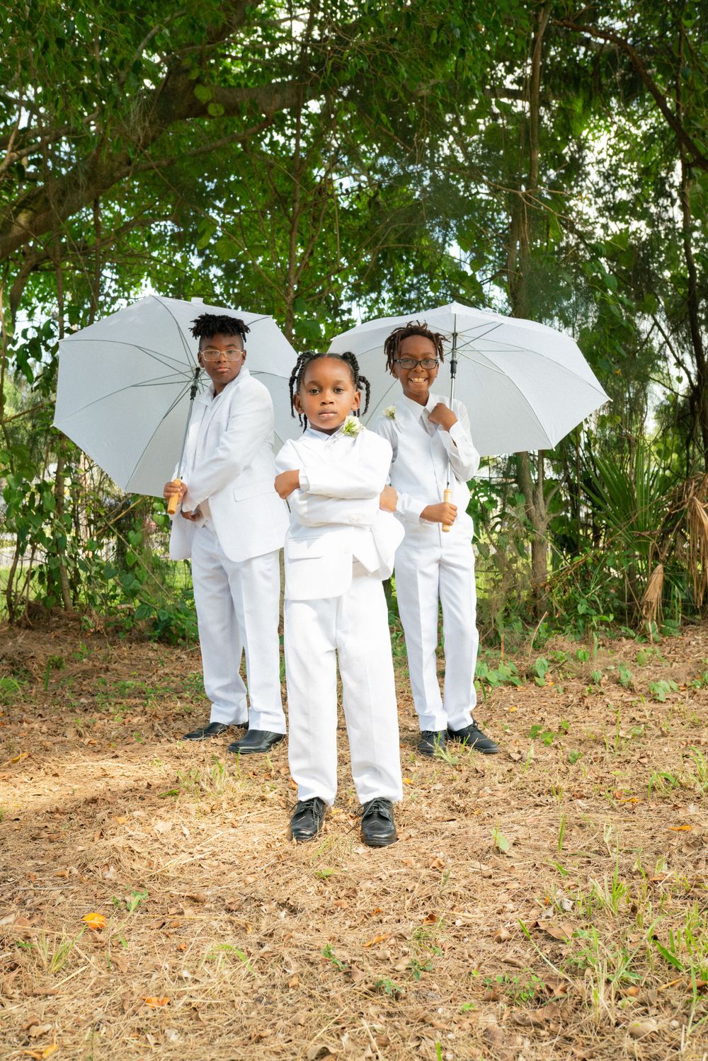 Family photo with white parasols in outdoor garden setting.