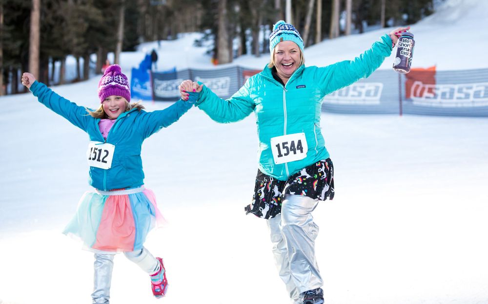 Two runners raise their hands in celebration as they finish the 2020 GORE-TEX Kahtoola Uphill.