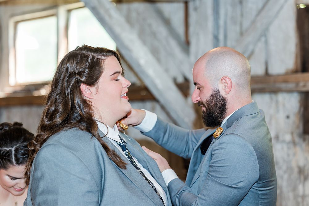 An emotional moment shared between wedding party members in a rustic venue.