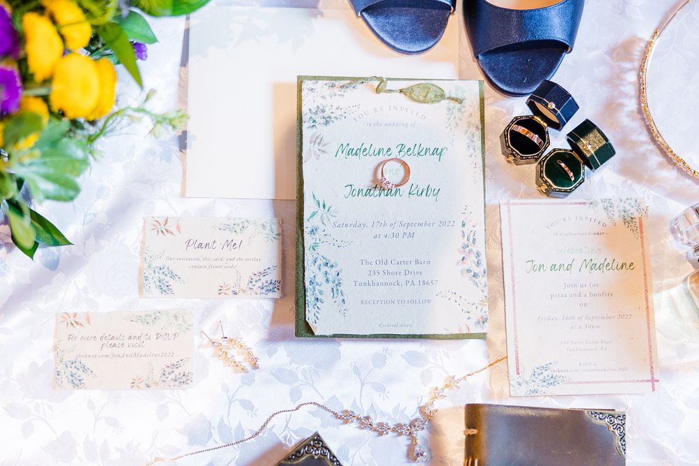 Elegant floral wedding invitations styled with sunglasses and yellow flowers on white linen.