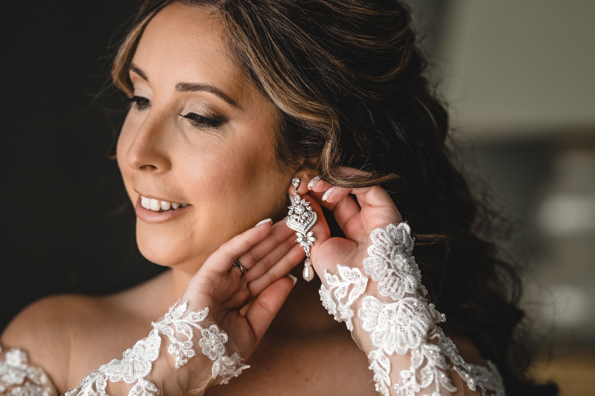 Close-up details of bridal jewelry and accessories being put on.