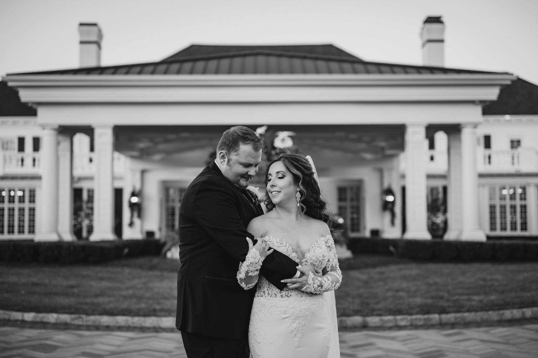 Black and white wedding photos showcasing a grand estate's elegant exterior.