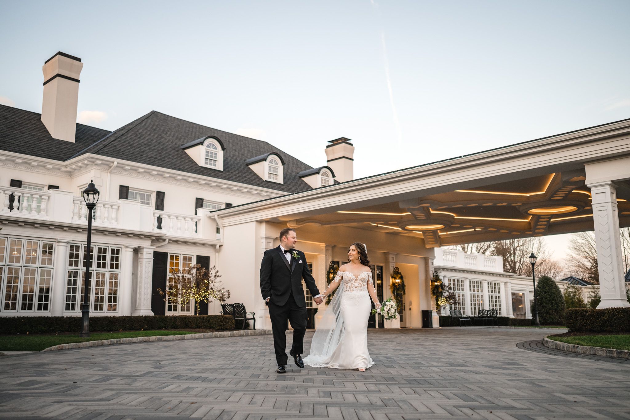 Panoramic view of a stately white wedding venue with classical columns and architecture.