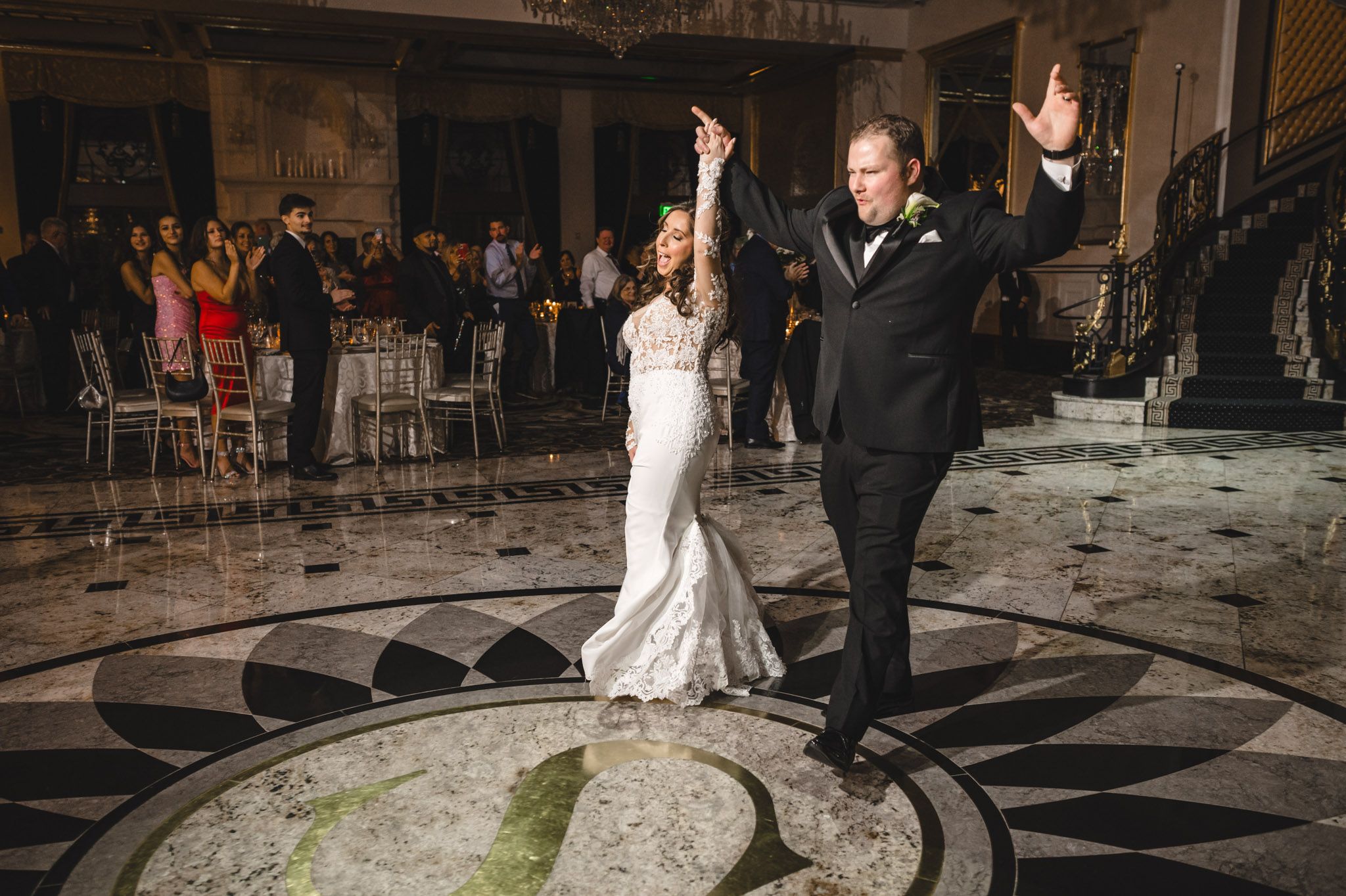 Couples dancing on a patterned ballroom floor at an elegant evening wedding reception.