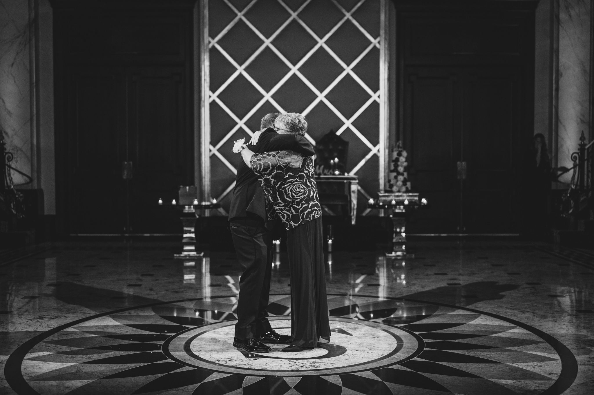 Elegant ballroom dance scene with decorative floor patterns and ambient lighting.