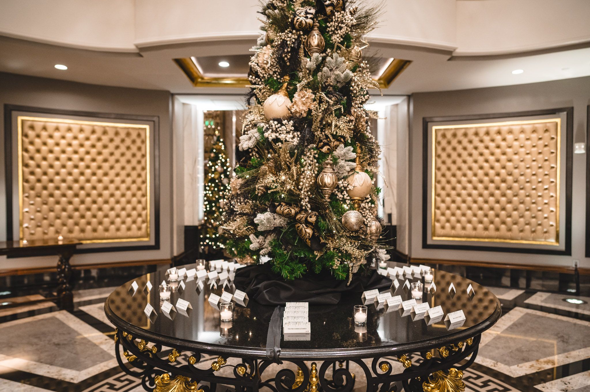Luxurious wedding reception venue with crystal chandeliers and tufted wall panels.